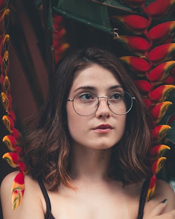 Close-up Photography of Woman Wearing Black Framed Hippie Glasses