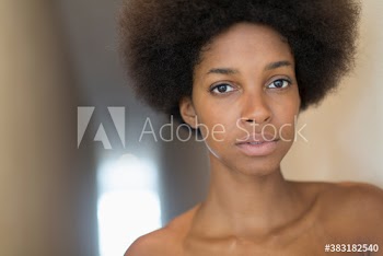 Close up portrait beautiful young woman with afro and bare shoulders