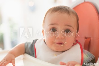 Close up portrait cute baby boy in high chair