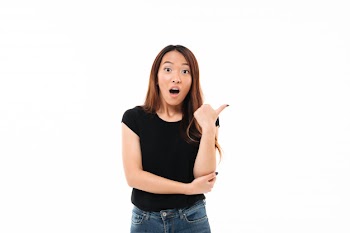 Close-up portrait of shocked young pretty asian woman showing thumb up gesture, looking at camera Free Photo