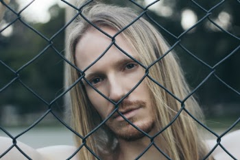 Close-up Portrait Photo of Man Behind Chain Link Fence