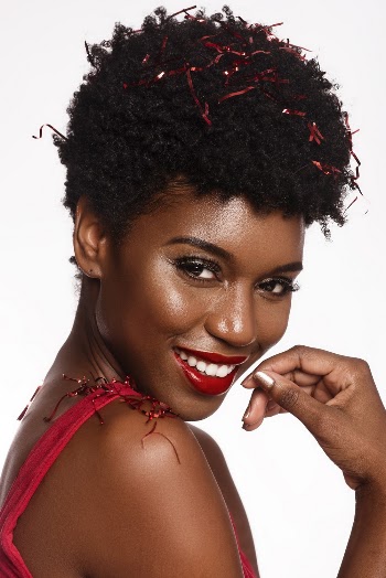 Close-up Portrait Photo of Smiling Woman in Red Sleeveless Top Posing With Confetti on Her Hair and Shoulder