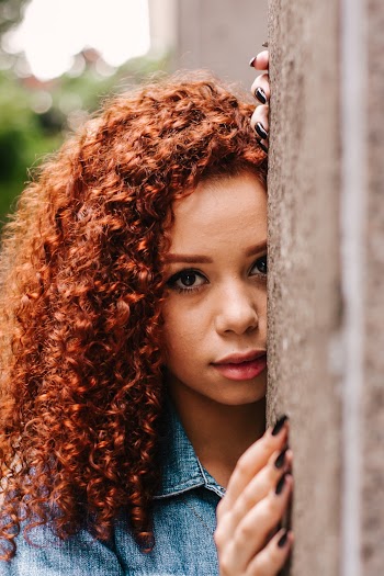 Close-up Portrait Photo of Woman Leaning on Concrete Wall