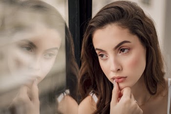 Close-up Portrait Photo of Woman Sitting by Window Looking Outside