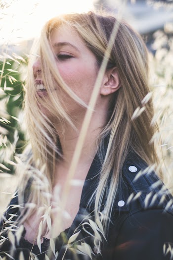 Close-up Side View Photo of Smiling Woman in Black Top  and Jacket Posing With Her Eyes Closed