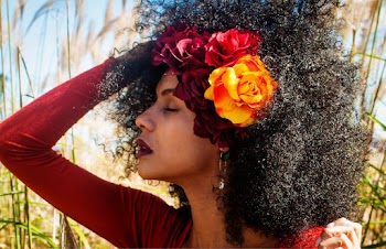 Close-up Side View Photo of Woman in Red Top and Flowers in Her Posing With Her Eyes Closed