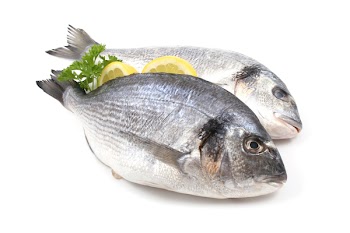 close-ups of two dorada fish with lemon and parsley isolated on white