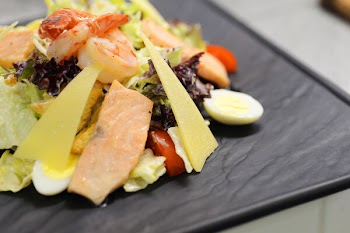 Close view of fresh salad with salmon, cheese, eggs and tomatoes