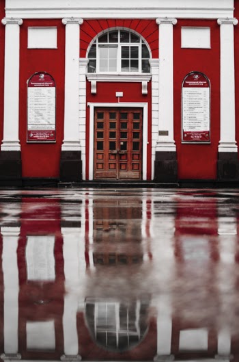 Closed Brown Wooden Door With Reflection on Concrete Wet Floor