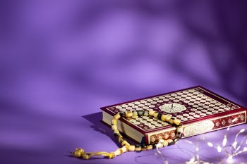 Closed quran on purple background Free Photo