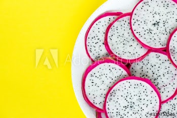 Closeup of a plate of dragon fruit slices on yellow background