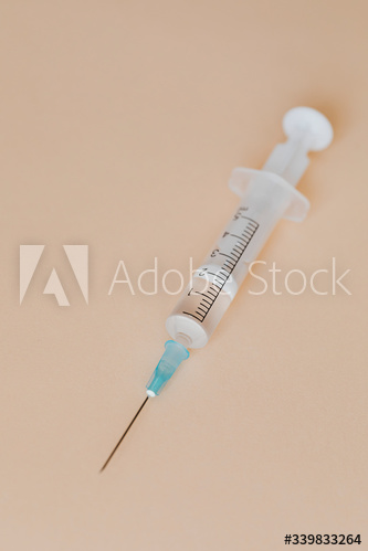 Closeup of a syringe on a brown background