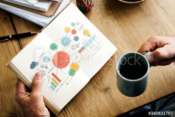 Closeup of hands holding open novel and coffee cup