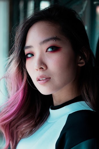 closeup photo of a woman black and white top with red eye shadow