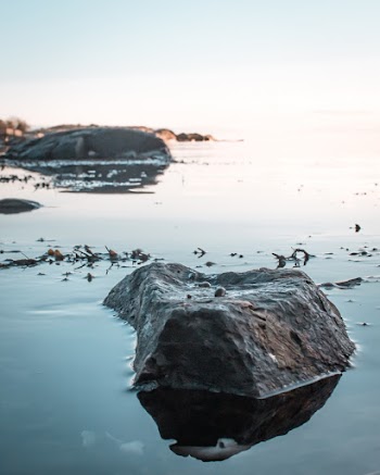 Closeup Photo of Black Stone Near Boulder