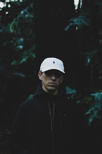 closeup photo of man in front of green leafed tree