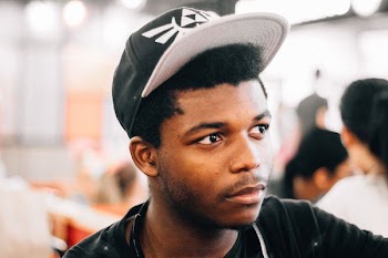 closeup photo of man wearing black and white cap