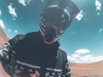 Closeup Photo of Man Wearing Black Racing Helmet Under Blue and White Sky
