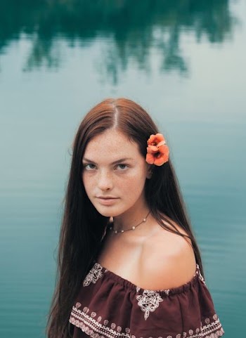 closeup photo of woman wearing blue top near body of water