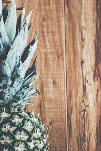 closeup photography of green pineapple and brown wooden planks