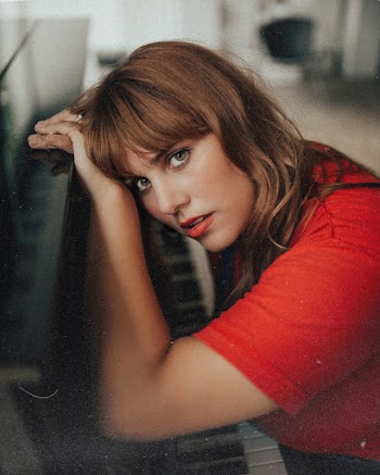 Closeup Photography of Woman Leaning on Black Grand Piano
