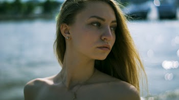 Closeup Photography of Woman With Gold Necklace Near Body of Water during Daytime
