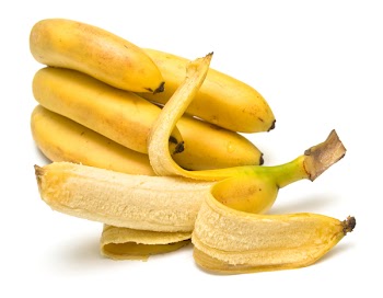 Cluster of ripe bananas. One banana is cleared away from a peel. Isolation, shallow DOF.