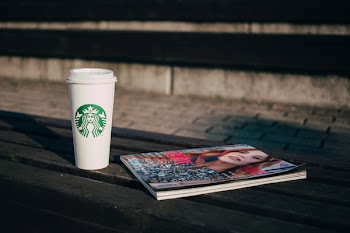 Coffee and a magazine on a bench