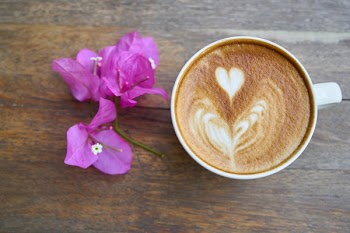 Coffee Latte in White Mug Beside Pink Flowers