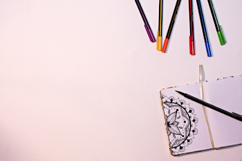 Color Markers on White Surface Near Book