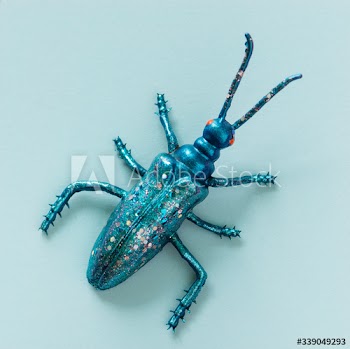 Colorful miniature bug on a paper
