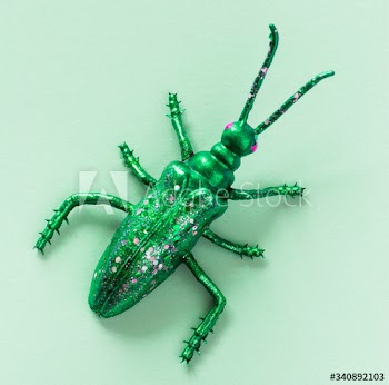 Colorful miniature bug on a paper