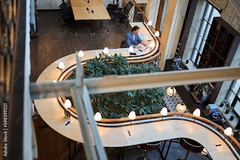 Concentrated man running his work tasks remotely from hotel lounge