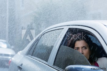 Concerned woman driving car in rain