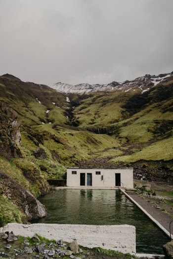 Concrete Building by Stream in Mountain Valley · Free Stock Photo