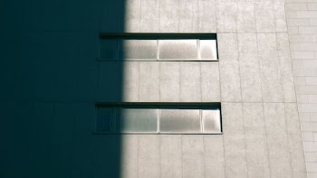 Concrete building with horizontal windows half in shadow