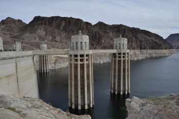 Concrete Road Under Calm Body of Water Above Clear Sky at Daytime