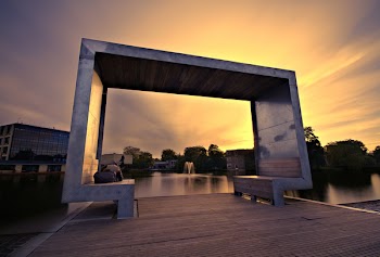 Concrete Shed Near Body Of Water During Golden Hour