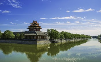 Concrete Temple Near Body of Water Under Blue Sunny Sky