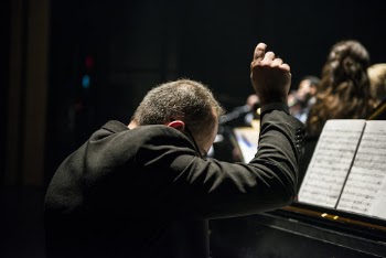 Conductor Sitting in Front of Songbook