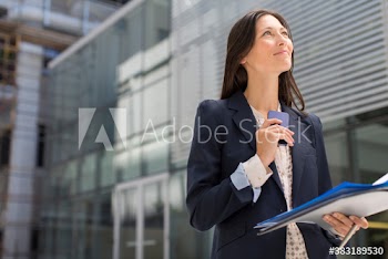 Confident businesswoman with paperwork and smart phone