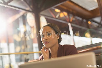 Confident businesswoman working in sunny restaurant