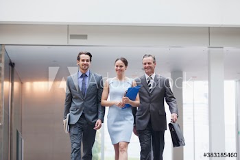 Confident corporate business people walking in office