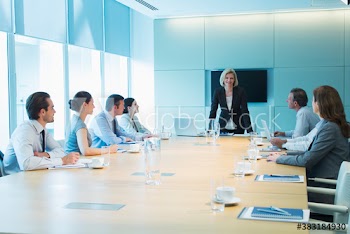 Confident corporate businesswoman leading conference room meeting