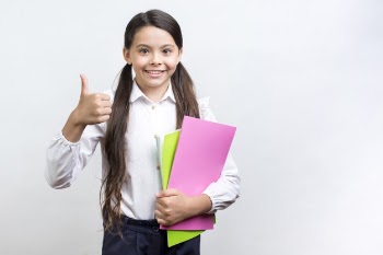 Confident hispanic schoolgirl with copybooks Free Photo