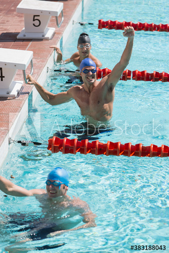 Confident male swimmer cheering and celebrating in swimming pool