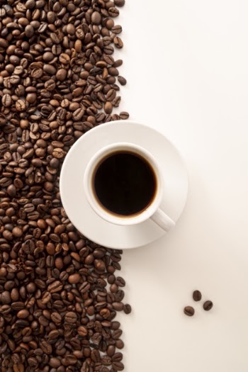 Contrasted coffee beans background and cup Free Photo