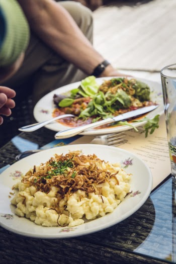 Cooked Pasta on White Ceramic Round Beside Vegetable Salad With Sauce