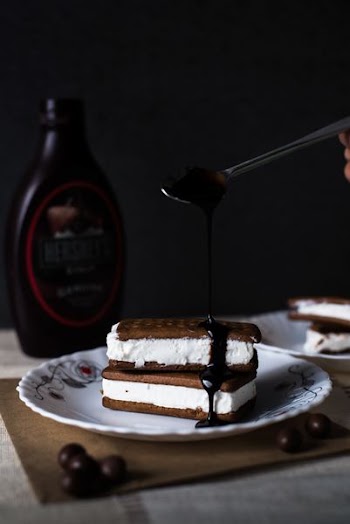 cookies with cream and chocolate sauce on top of plate