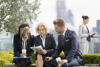 Corporate business people discussing paperwork in city park